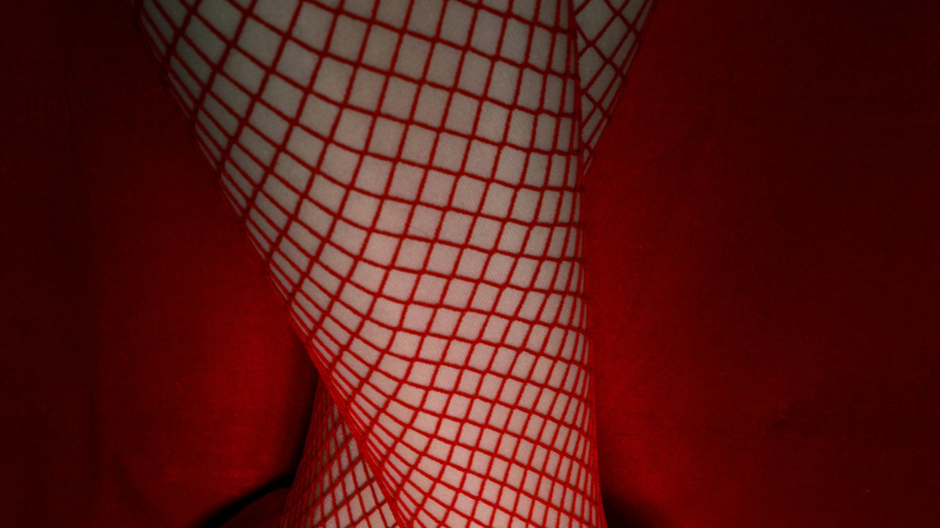 a close up of a person's legs wearing red shoes
