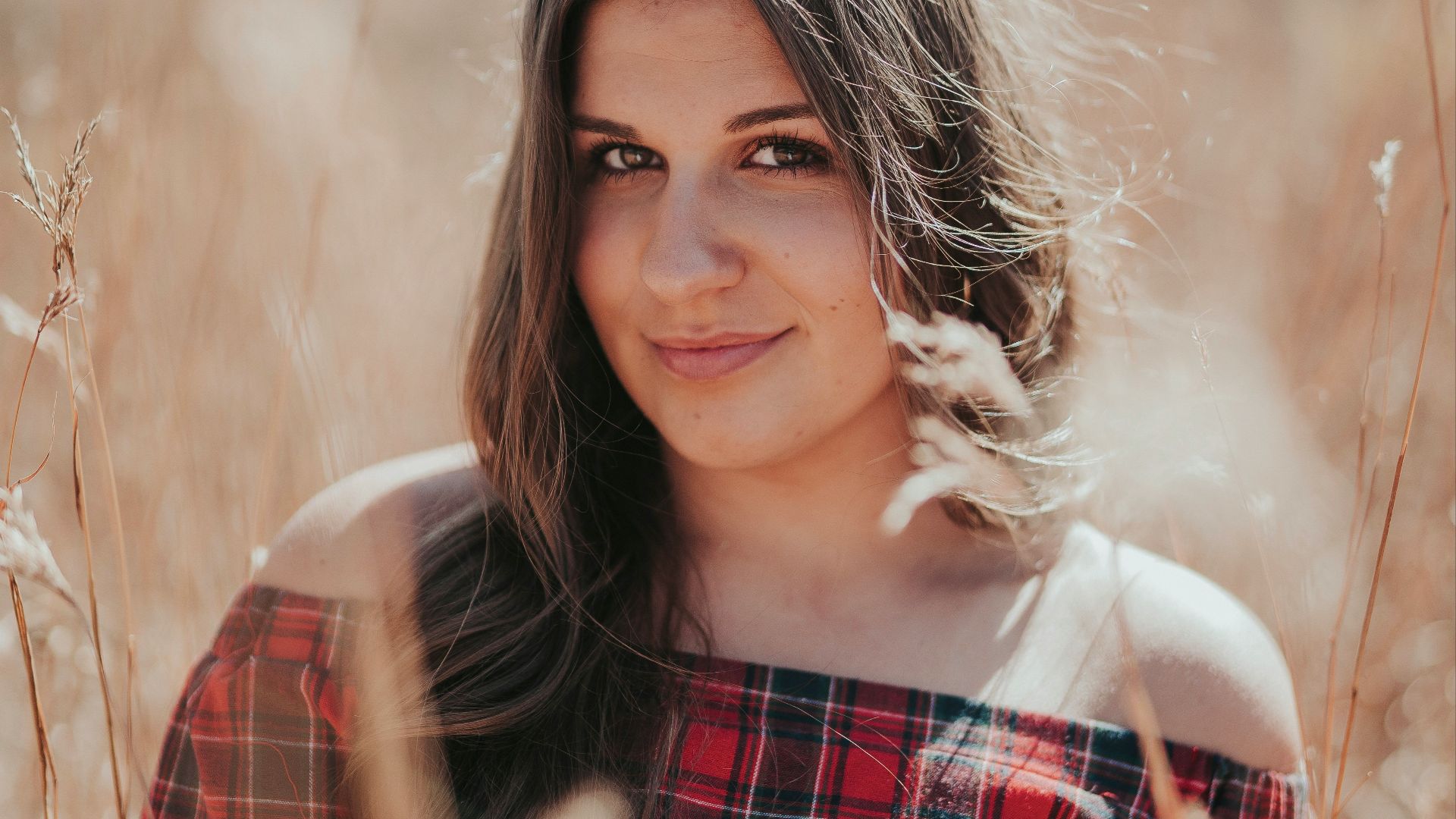 woman in red and black plaid dress shirt smiling