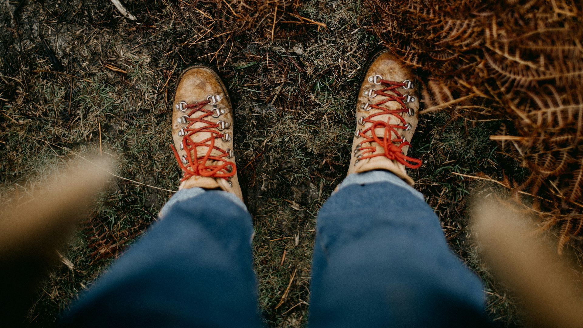 a person standing in the grass with their feet on the ground