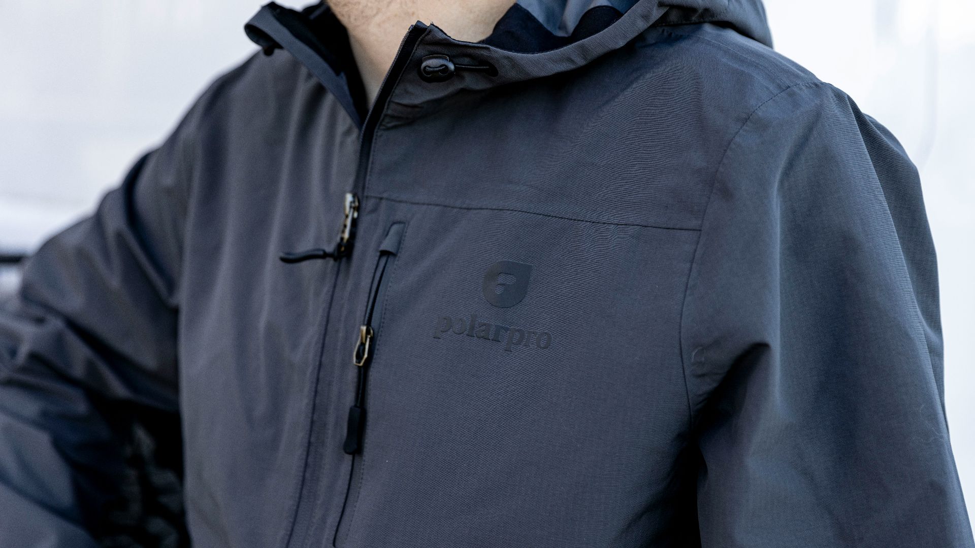 a man wearing a blue jacket and a black hat