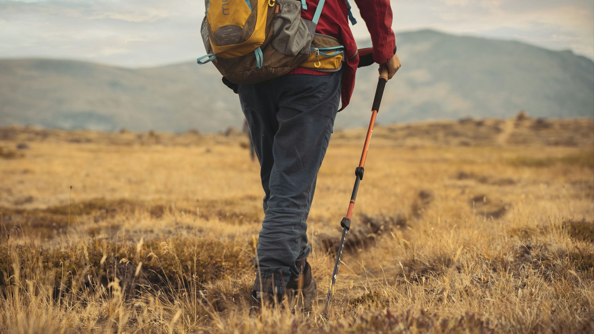 a man with a backpack walking through a field