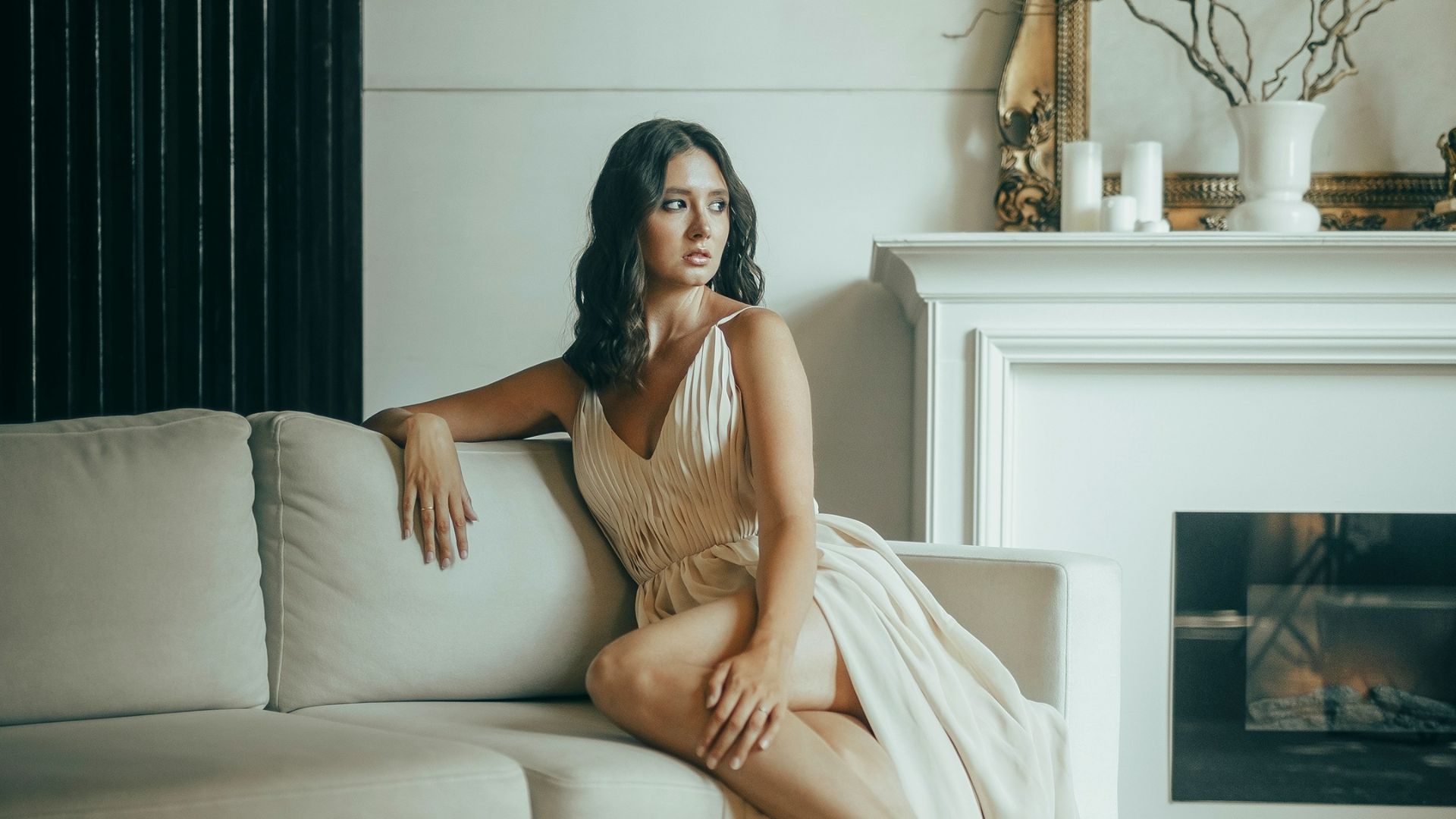 Woman in elegant dress sitting on sofa