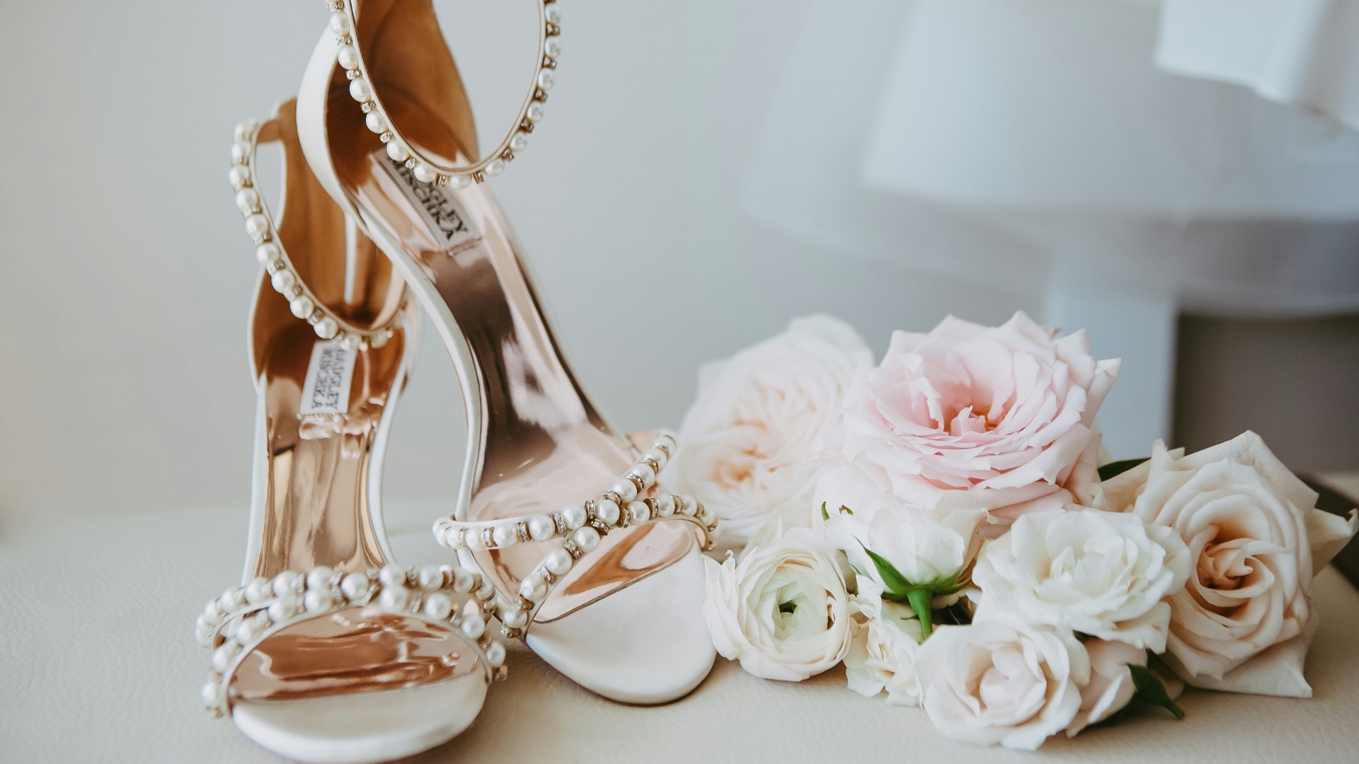 A bridal shoe and bouquet of flowers on a table