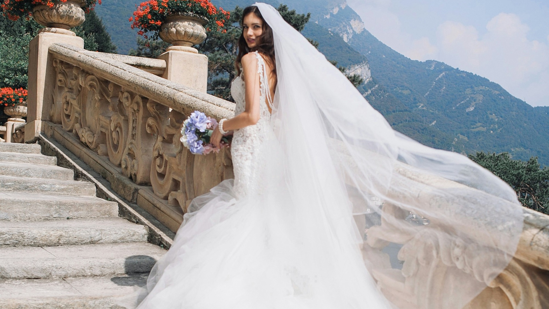 bride holding bouquet standing on white stairs