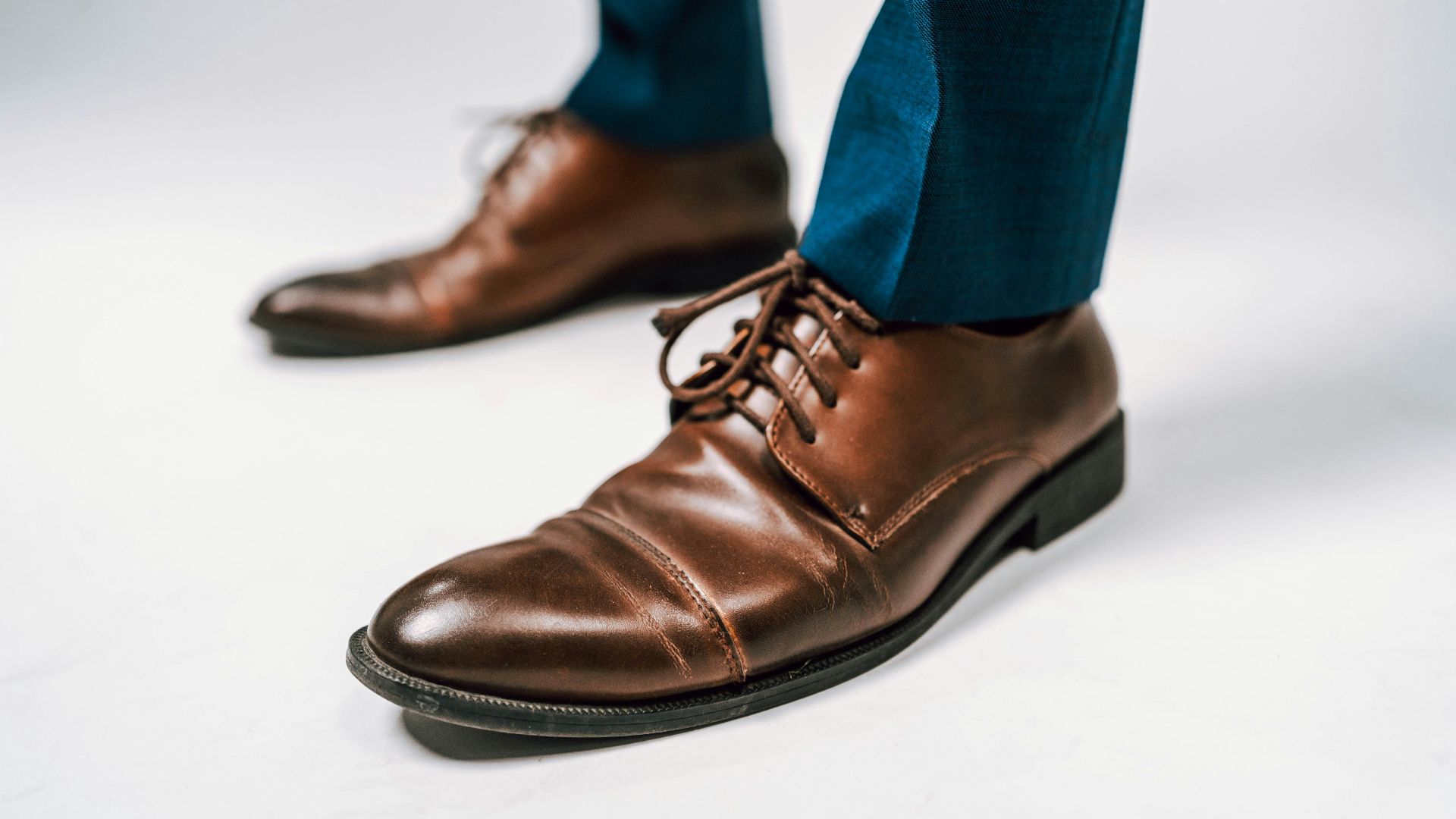 person in blue denim jeans and brown leather shoes