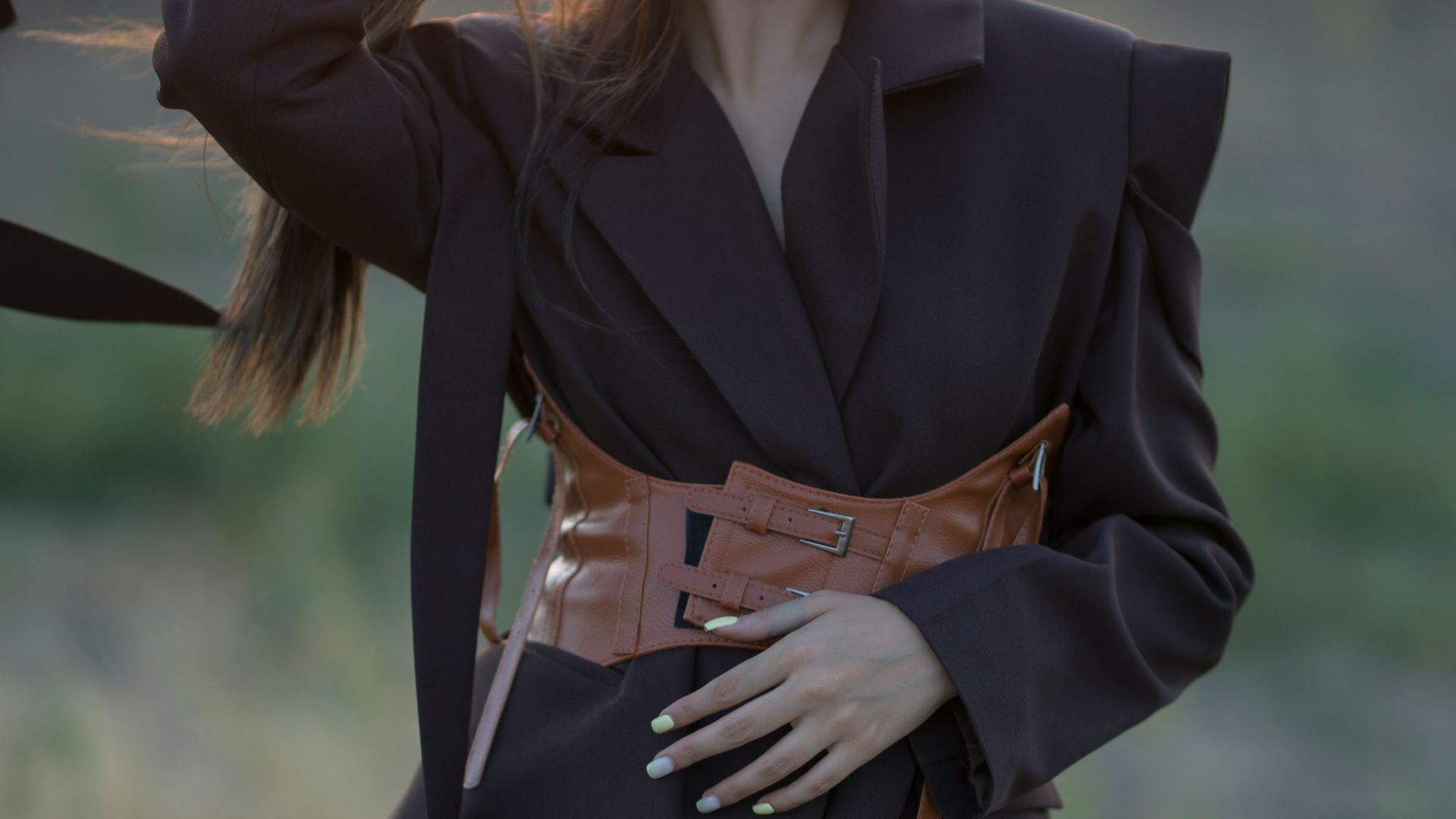 Woman posing in the sunset, wearing a blazer.