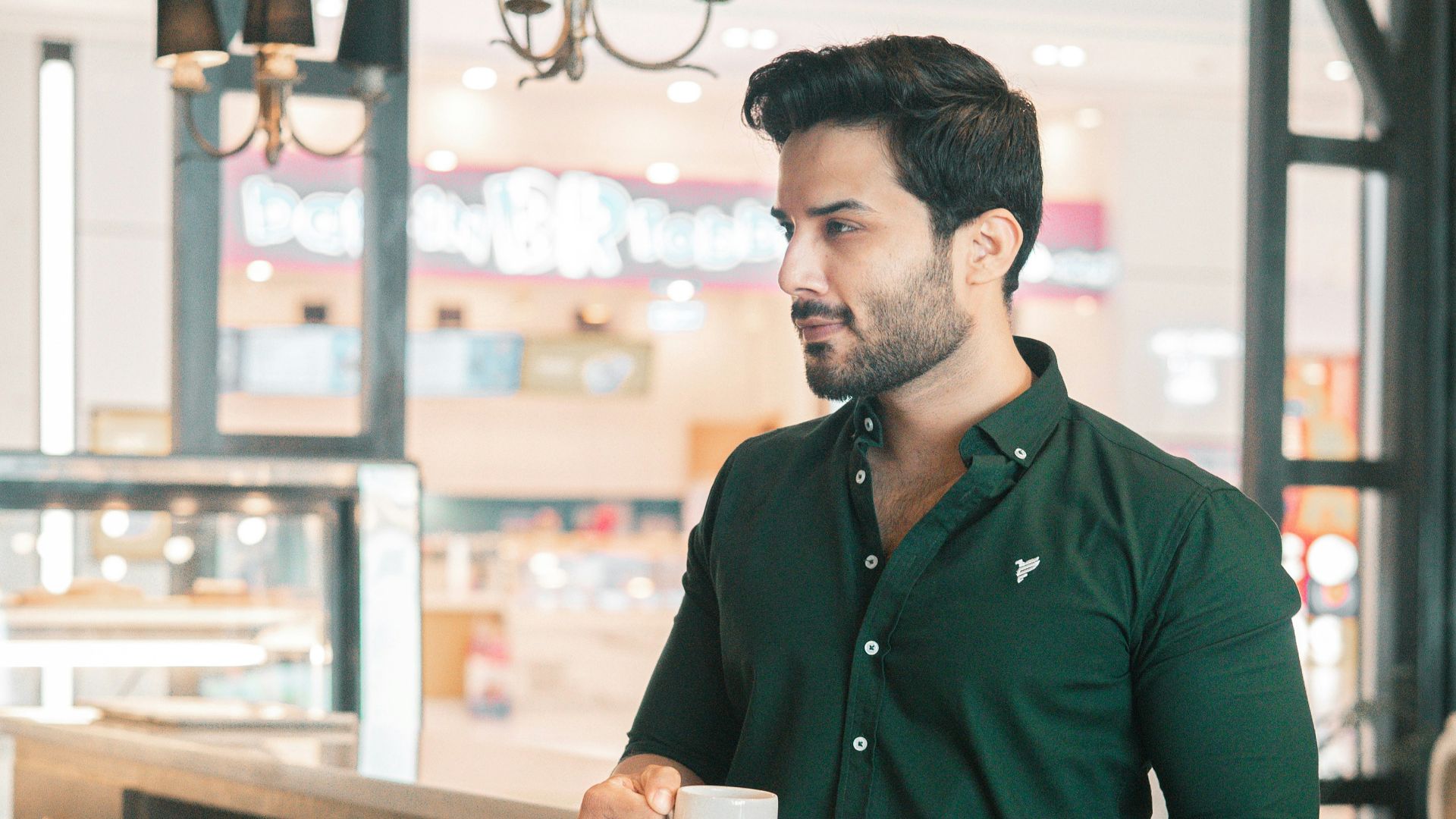 A man is drinking coffee in a cafe.