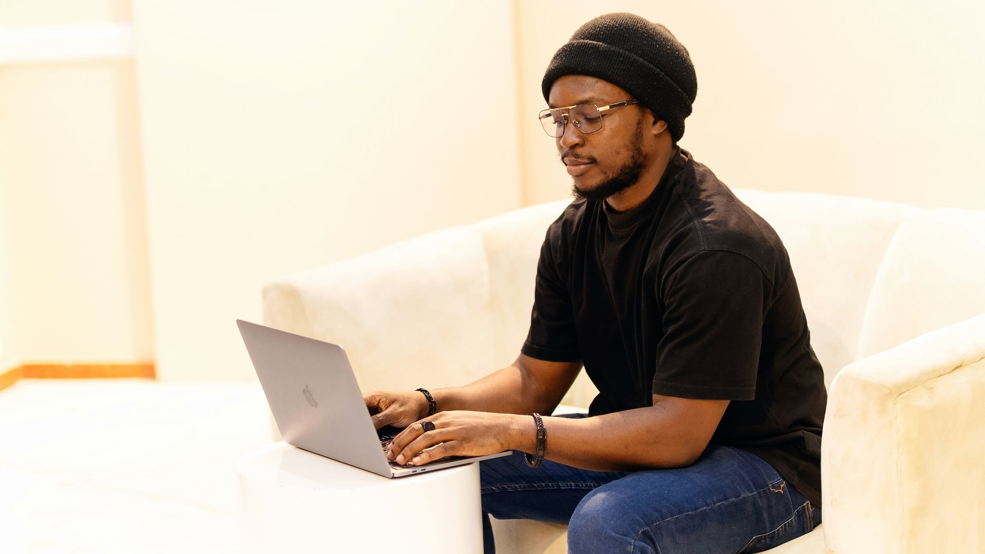A man sitting on a couch using a laptop computer
