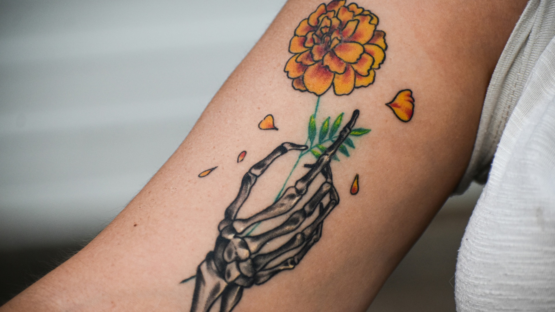 A person with a tattoo on their arm holding a flower