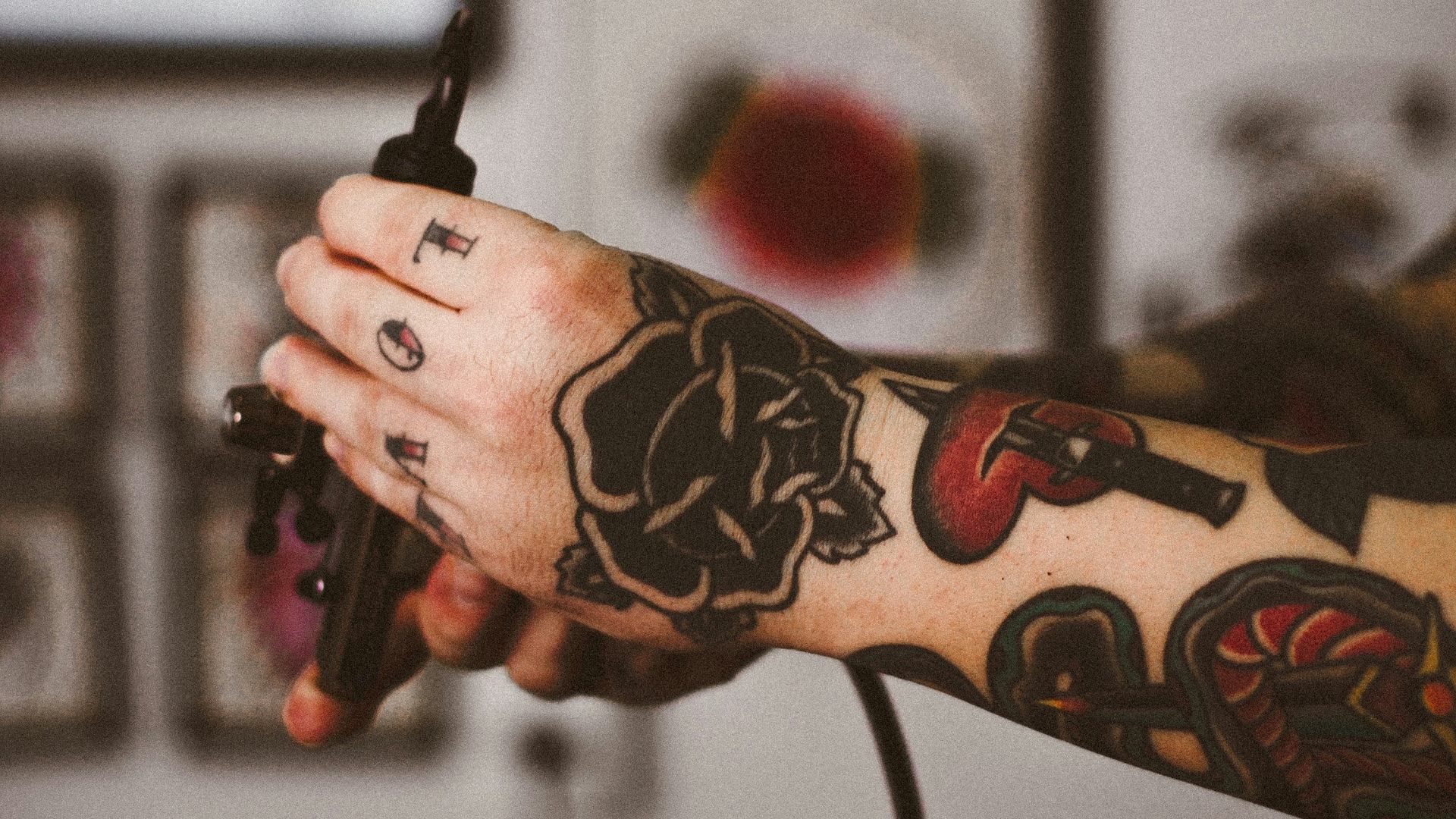shallow focus photography of person holding black tattoo machine
