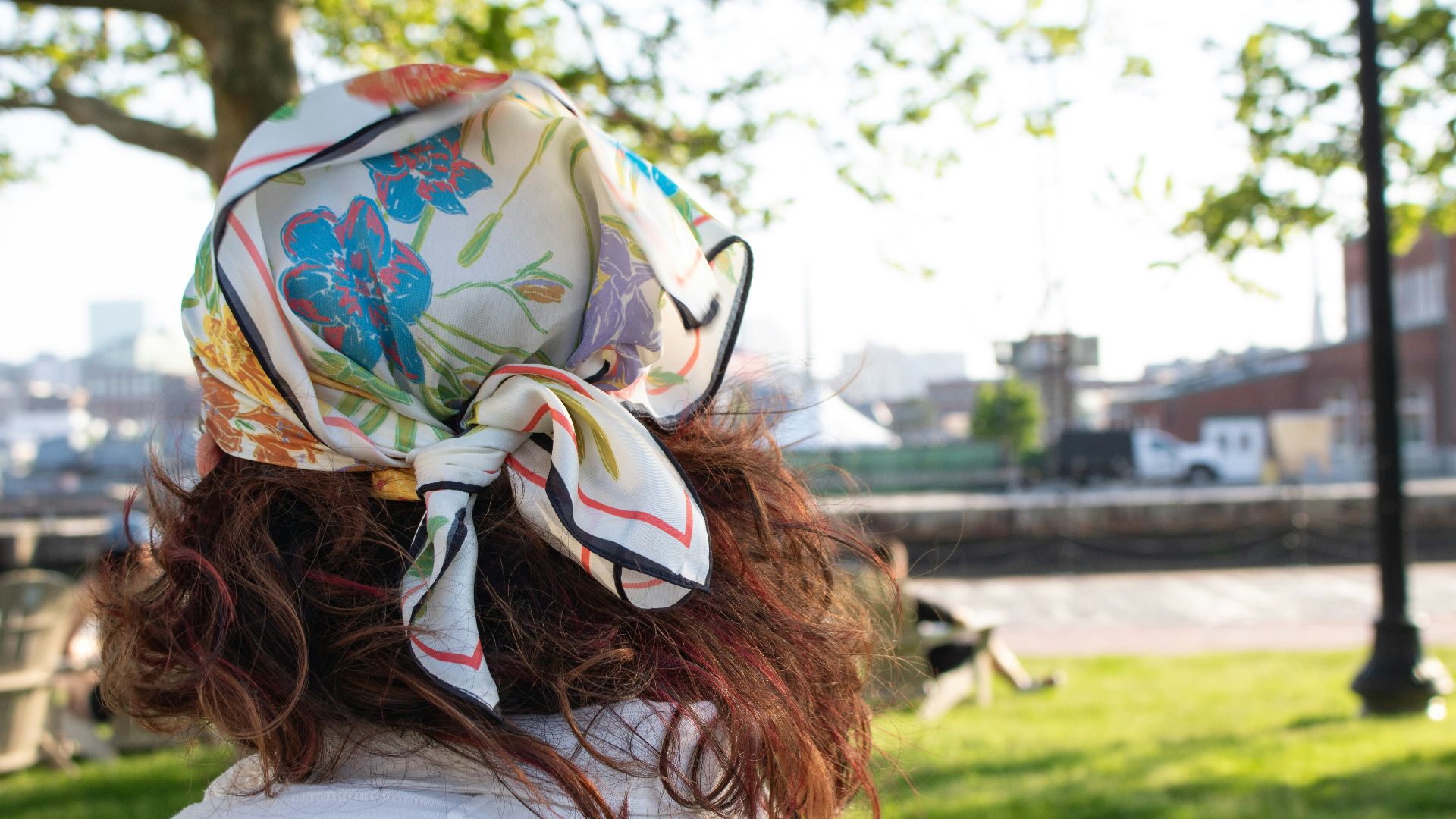 a woman in a park with a bandana on her head