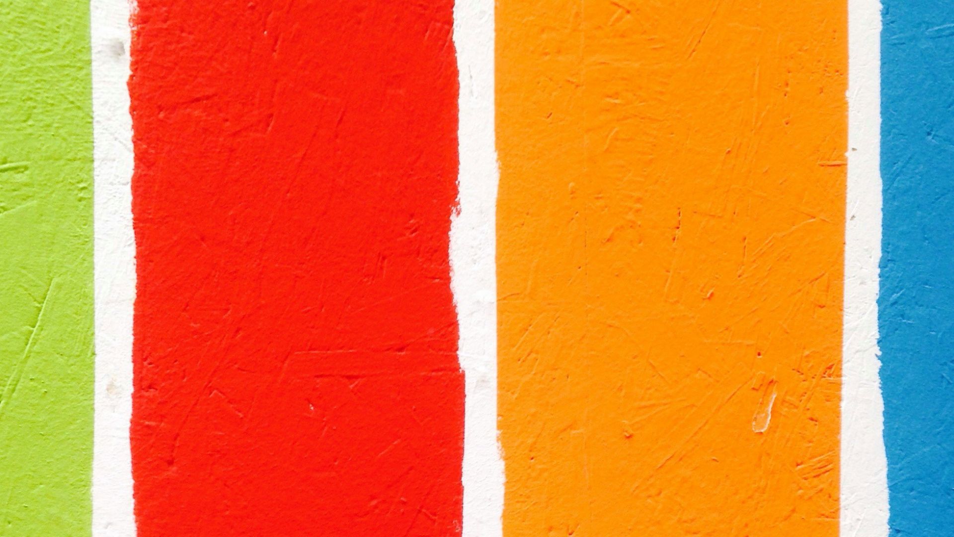 four orange, green, blue, and red paint rollers