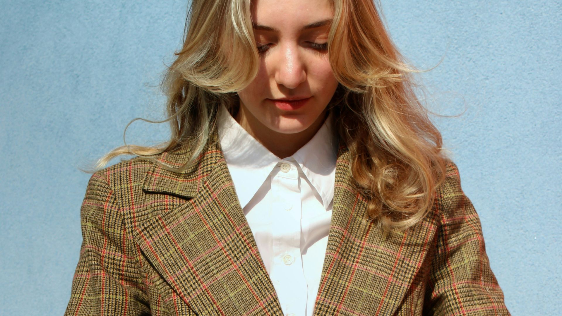 woman in brown and black plaid blazer standing