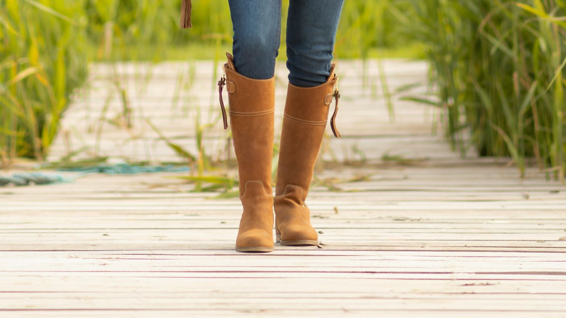 A woman standing on a dock with a hat on