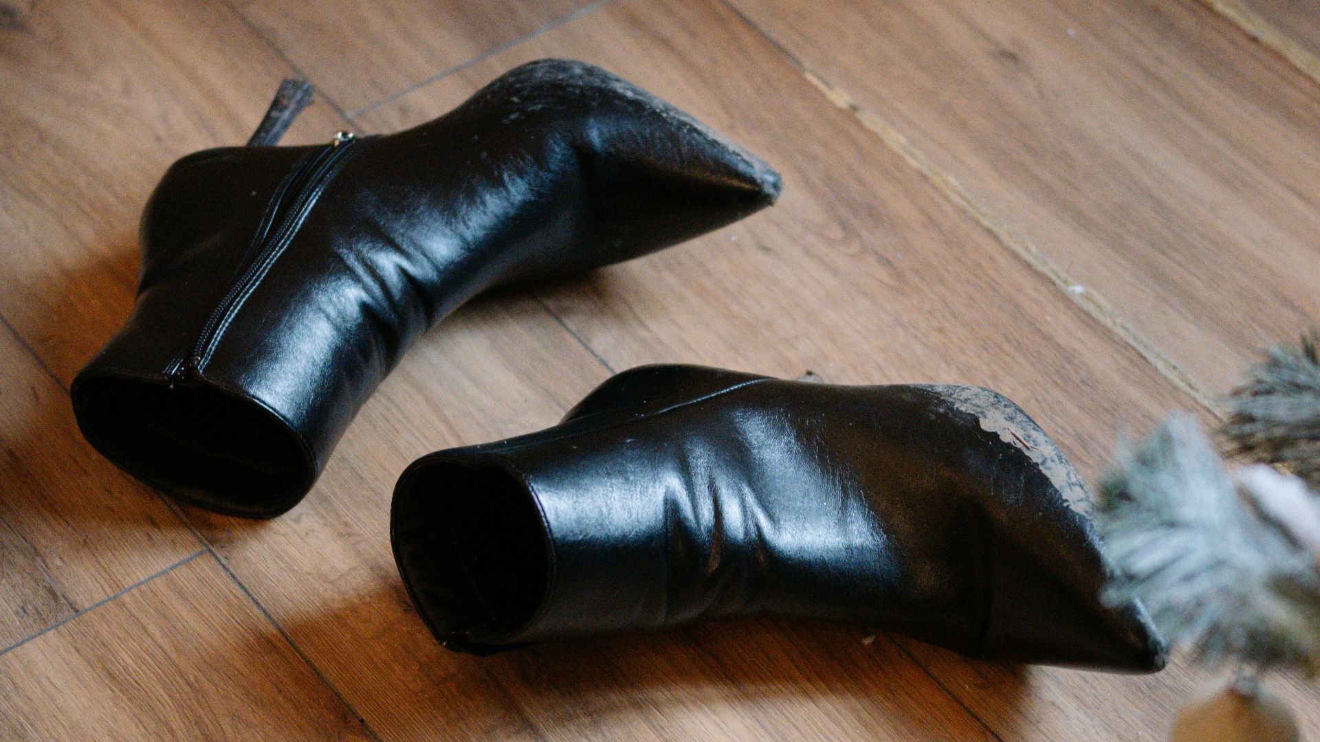 Black leather boots on a wooden floor.