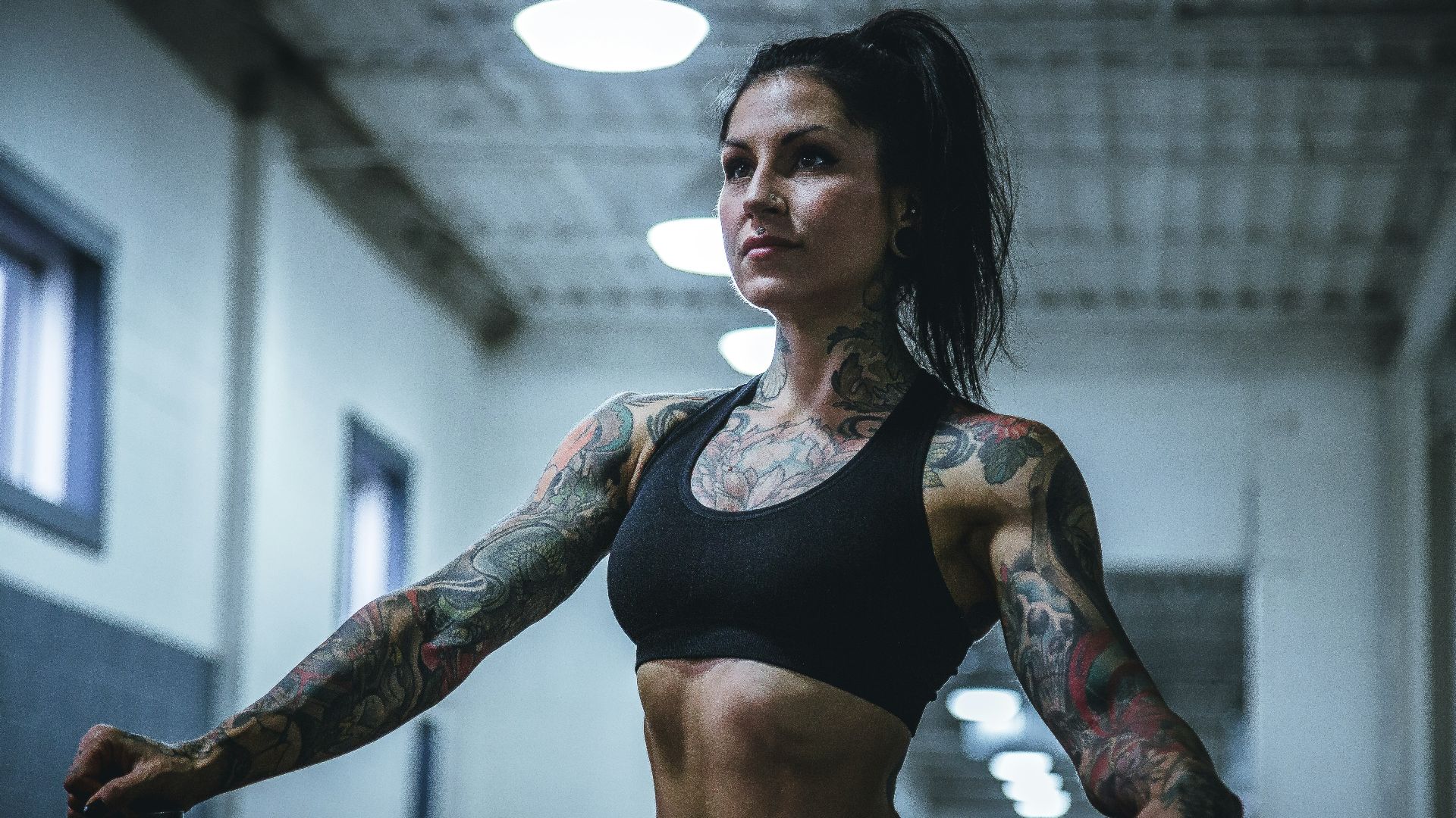 woman wearing black sports bra with tattoos