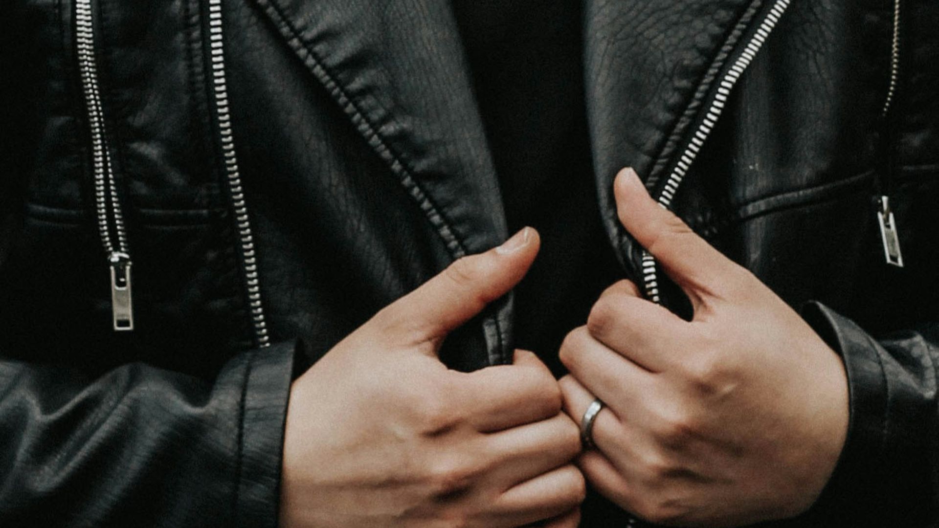 man holding his leather jacket