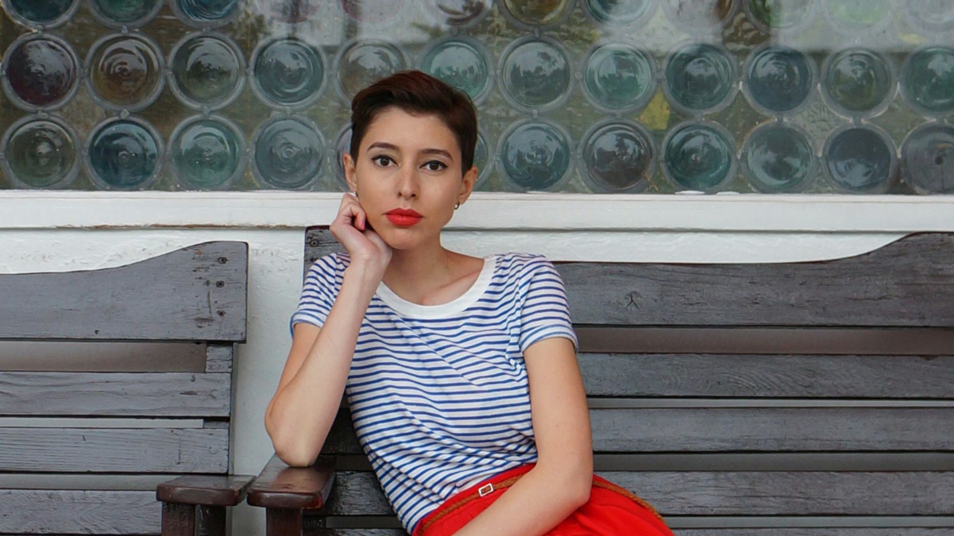 a woman sitting on a bench in front of a building