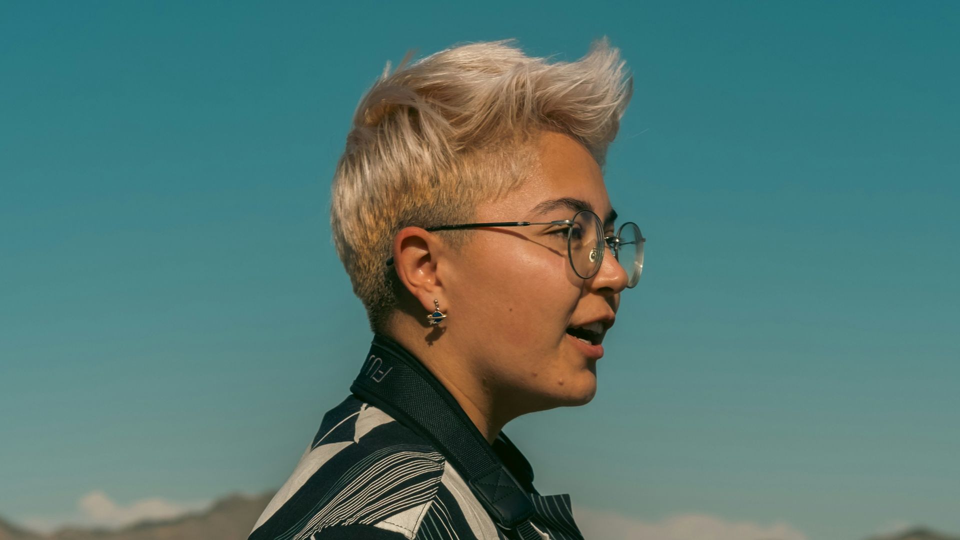 A woman standing in a field with a camera in her hand