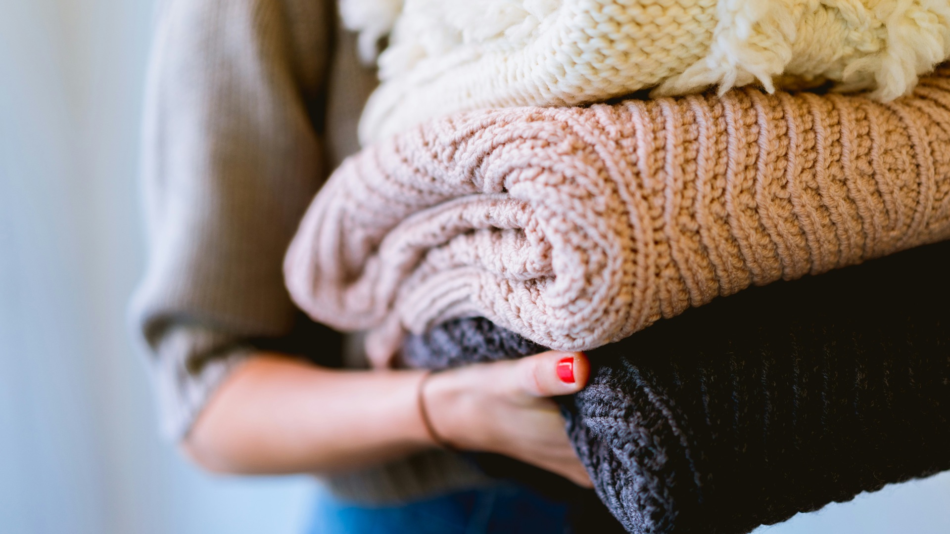 person holding knitted textiles