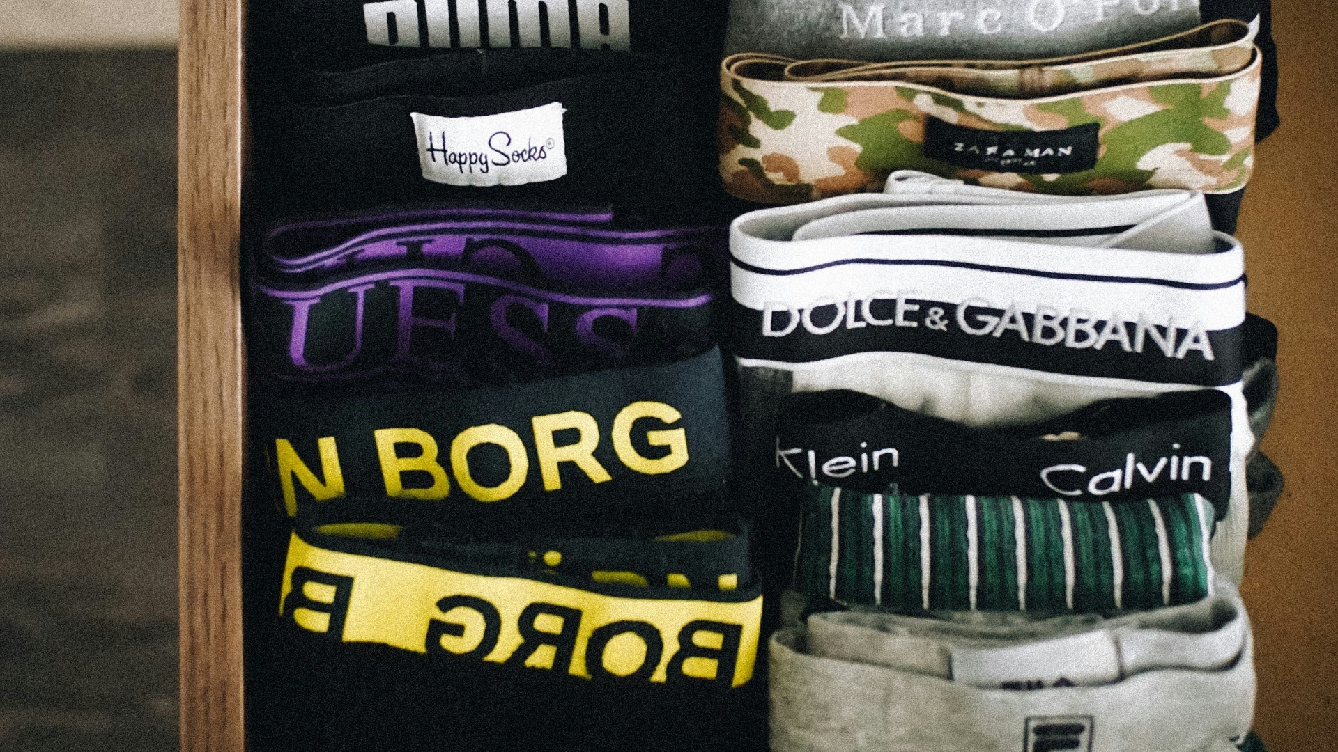 a person's feet resting on a shelf with a drawer full of shirts