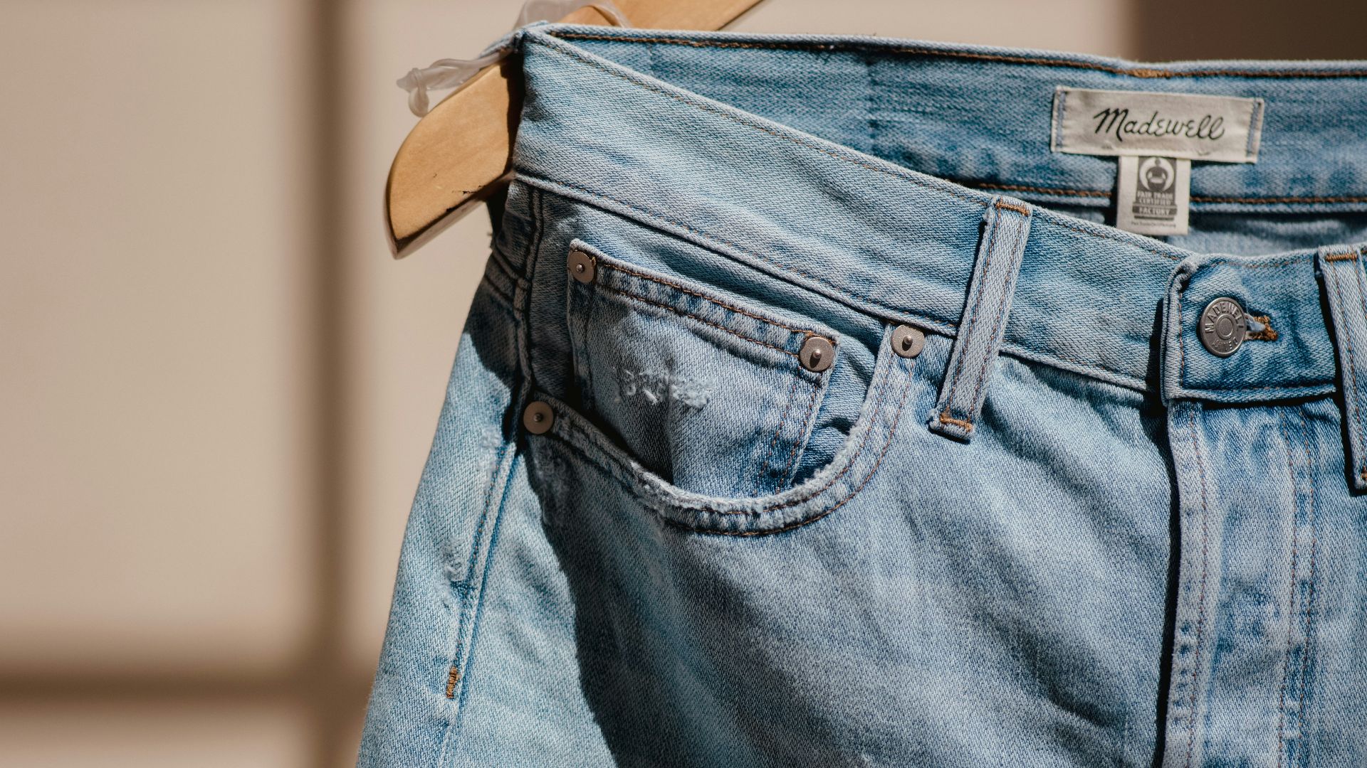 blue denim jeans on brown clothes hanger
