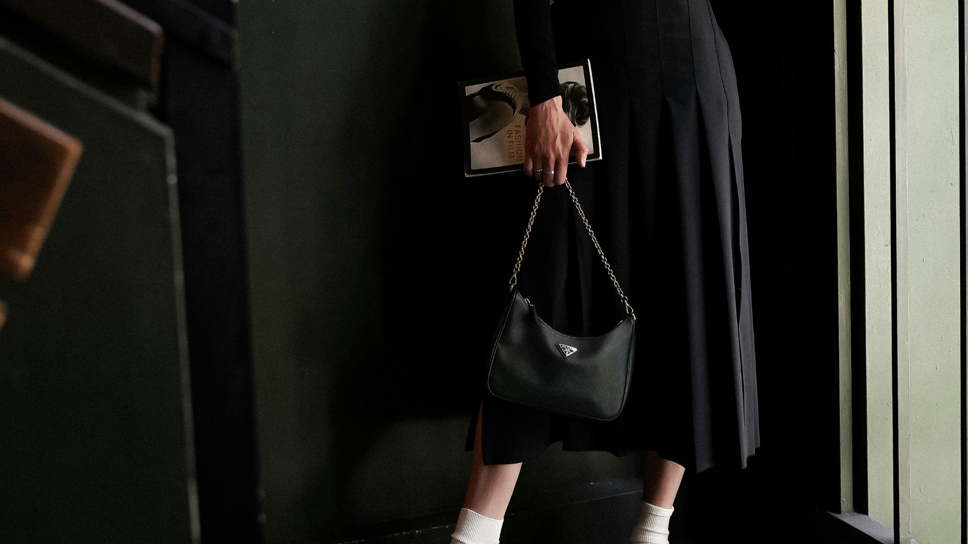 a woman in a black dress holding a purse