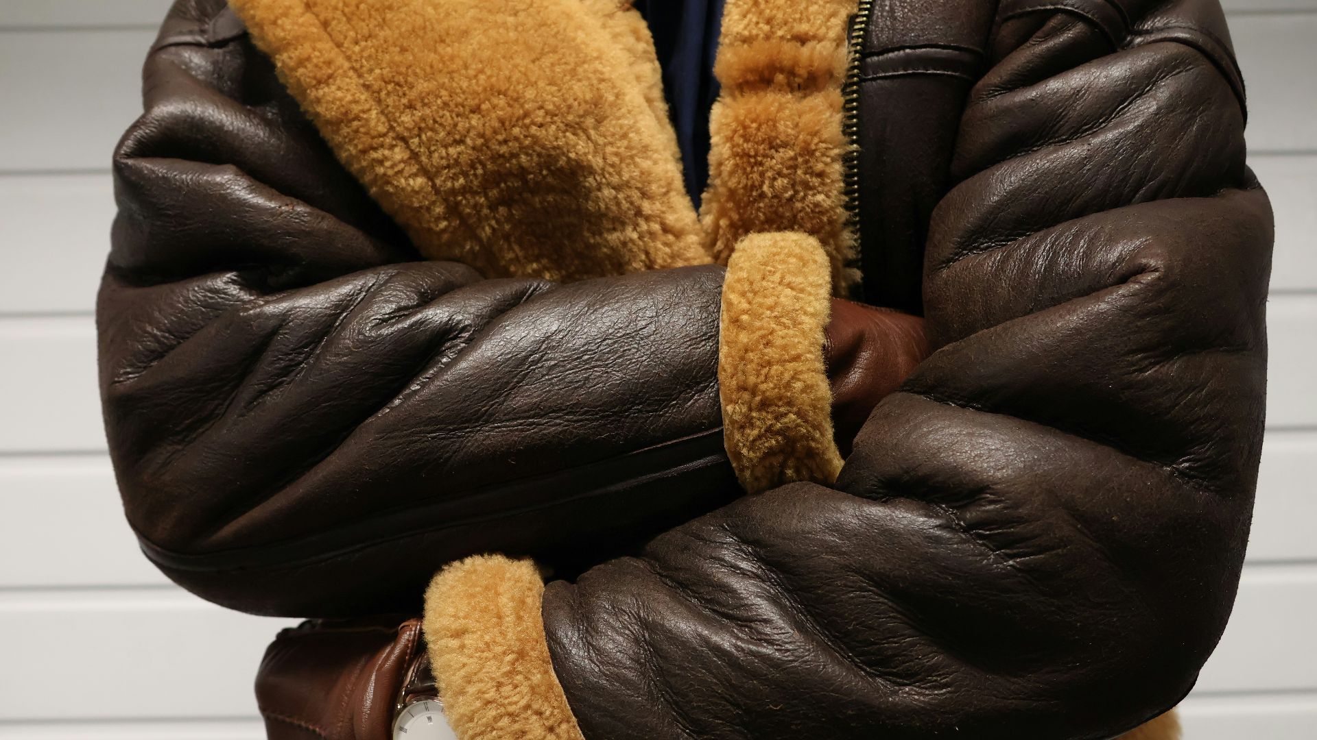 a close up of a person wearing a brown jacket