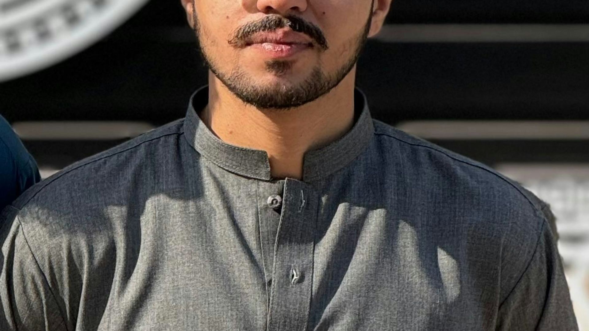 A man in traditional attire poses for a photo.