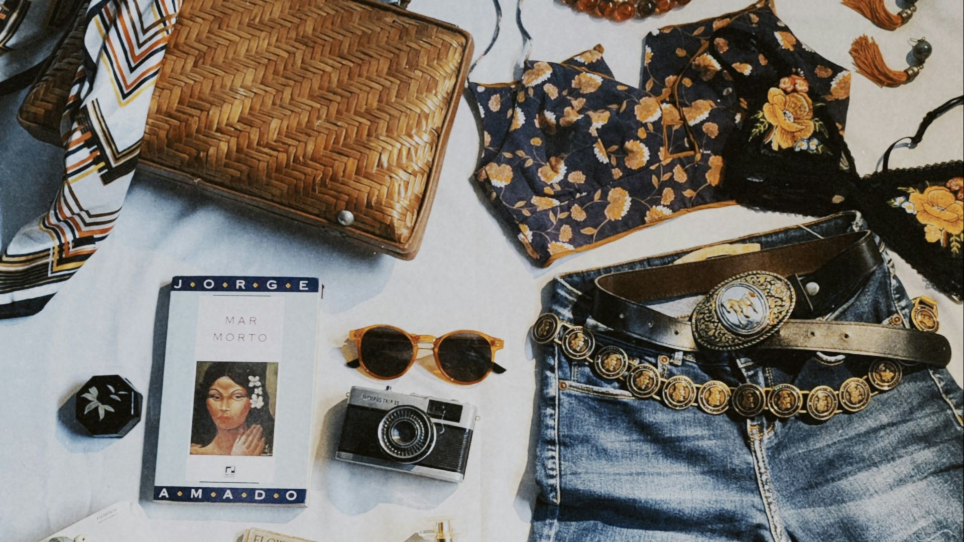 a variety of clothing and accessories laid out on a bed
