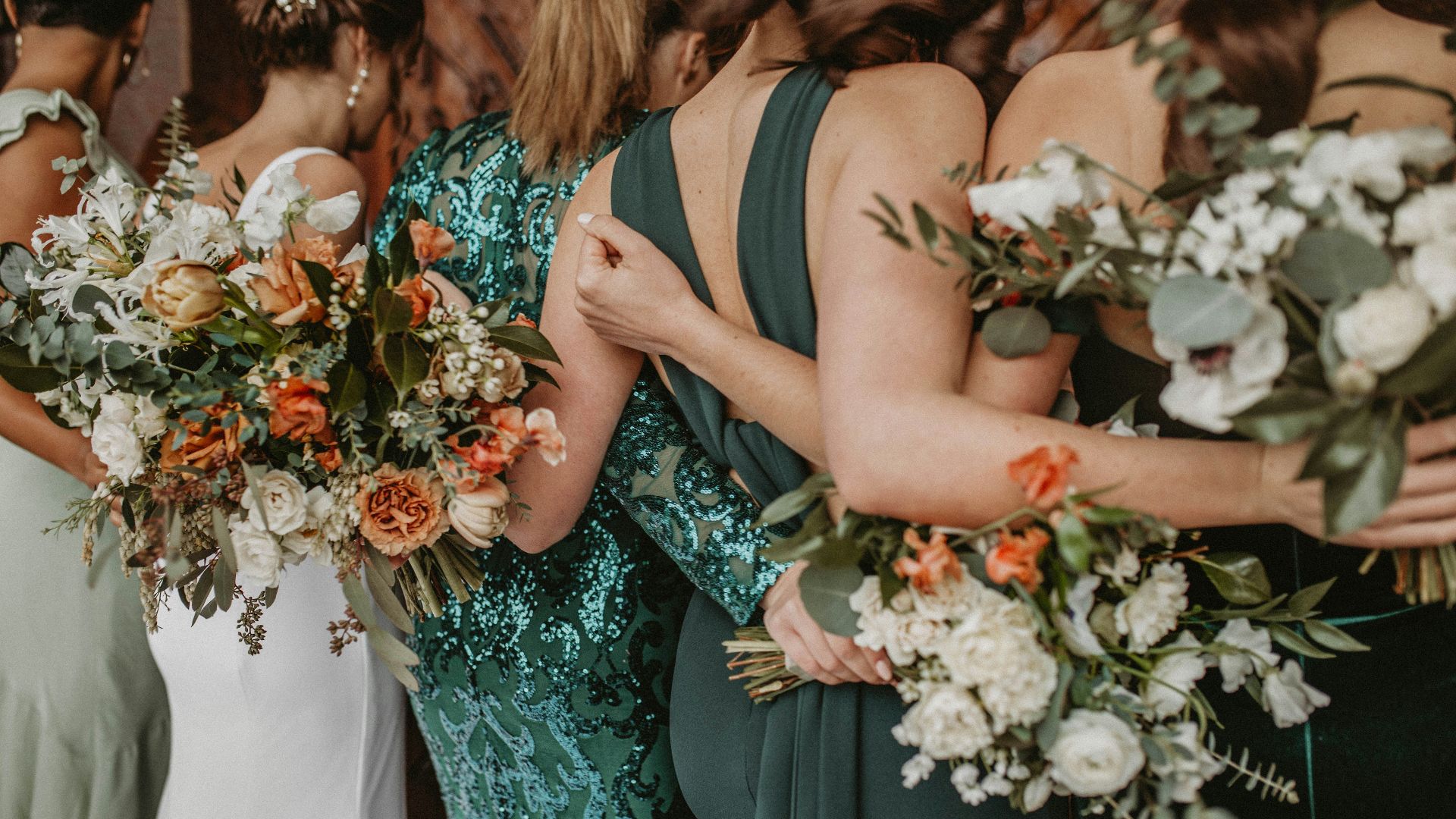 a group of women standing next to each other holding bouquets