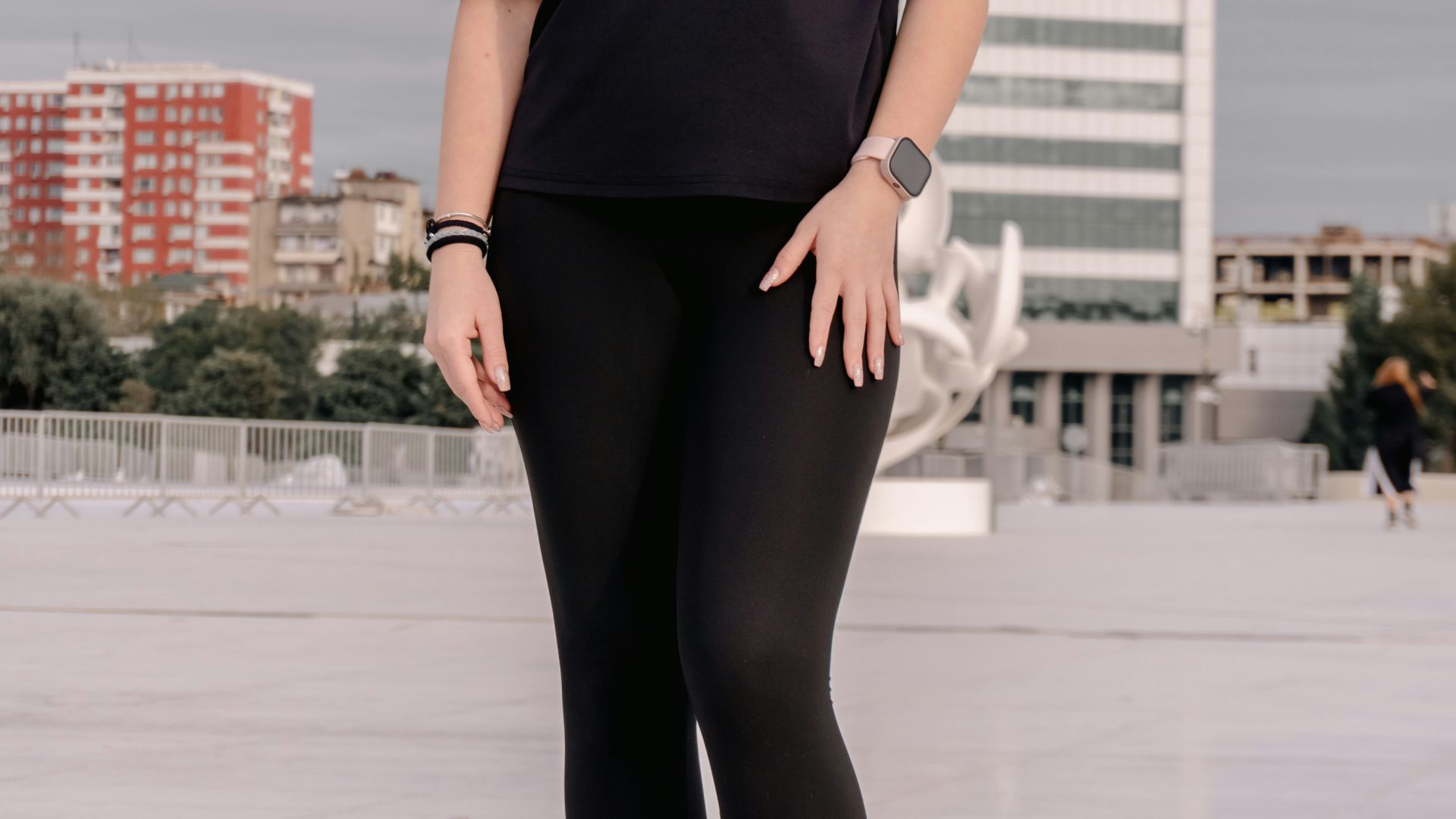Young woman in black outfit standing outdoors