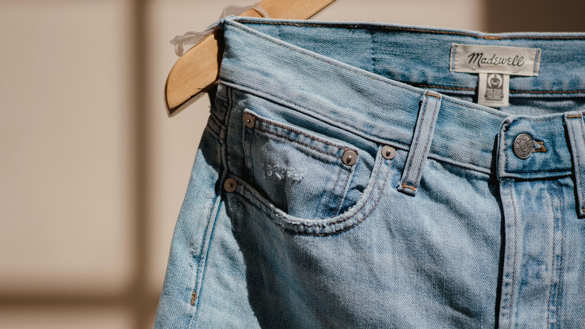blue denim jeans on brown clothes hanger