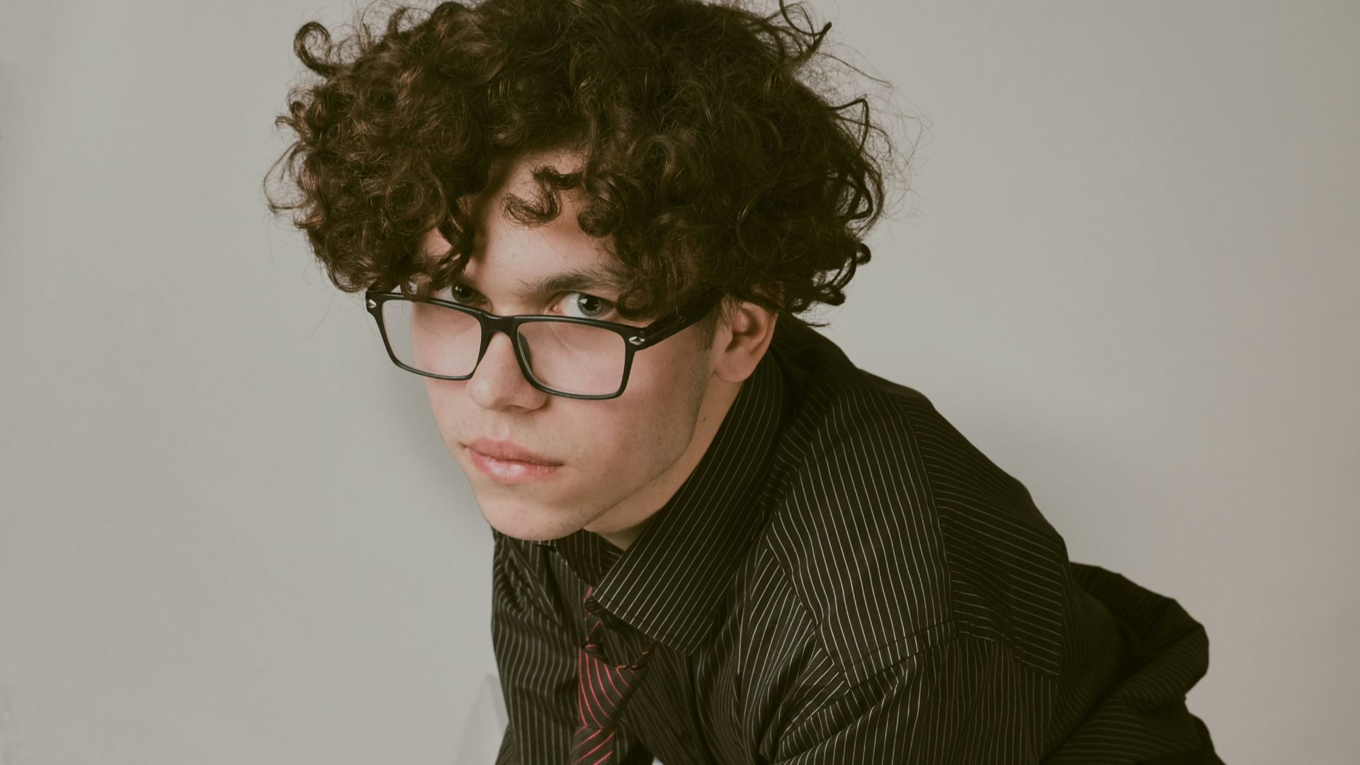 a man in a suit and tie leaning over a desk