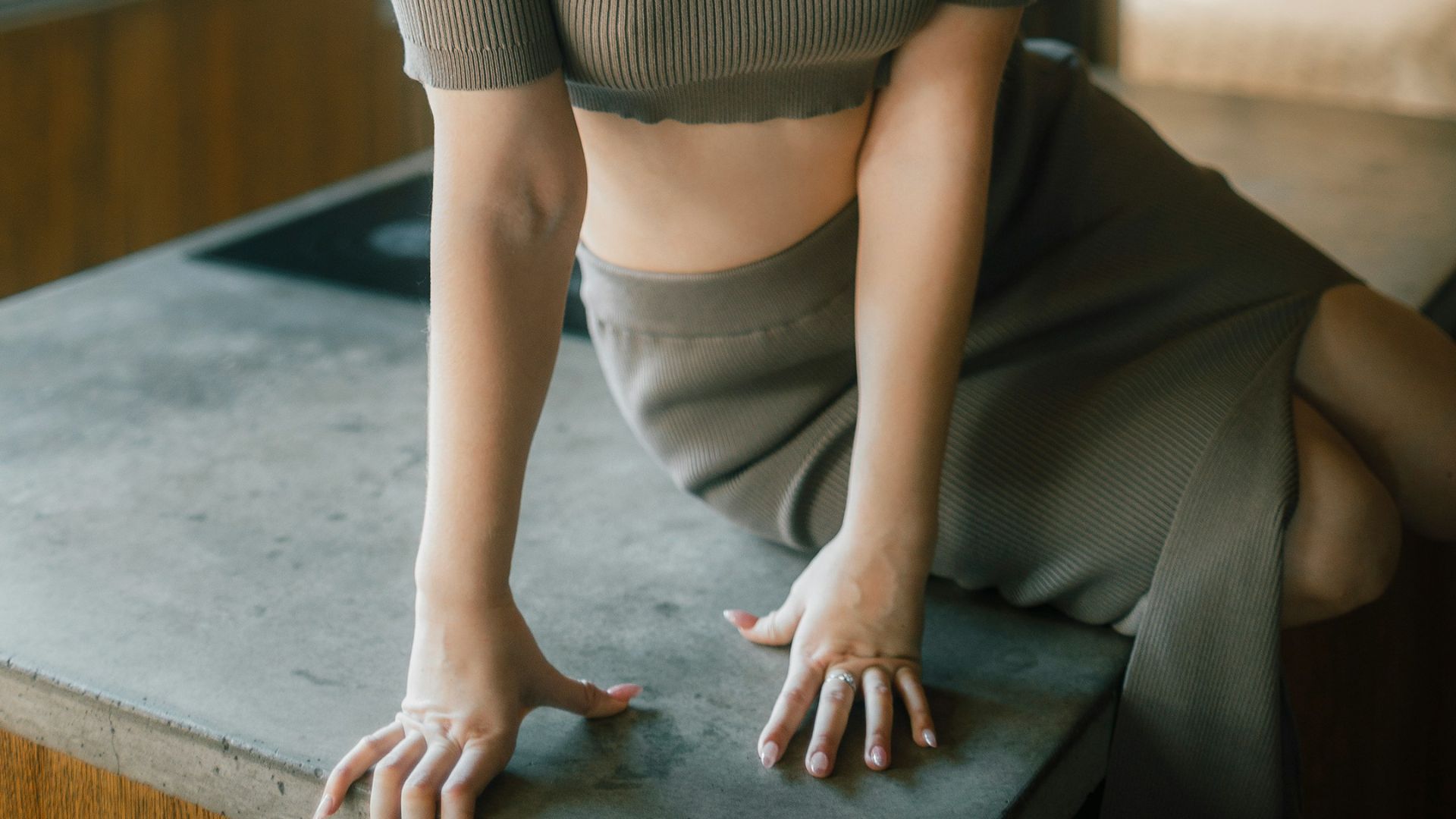 A young woman sitting on a kitchen counter