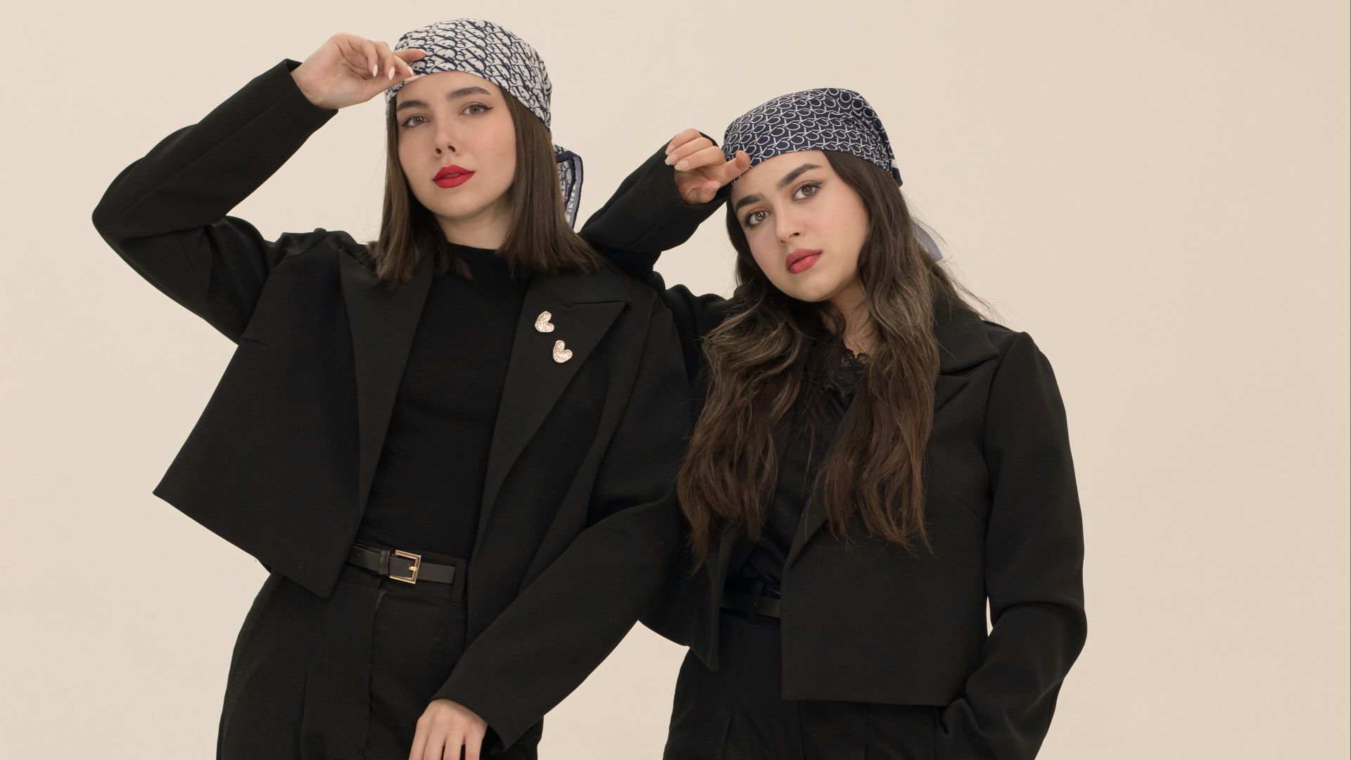 Two women in black suits and headscarves
