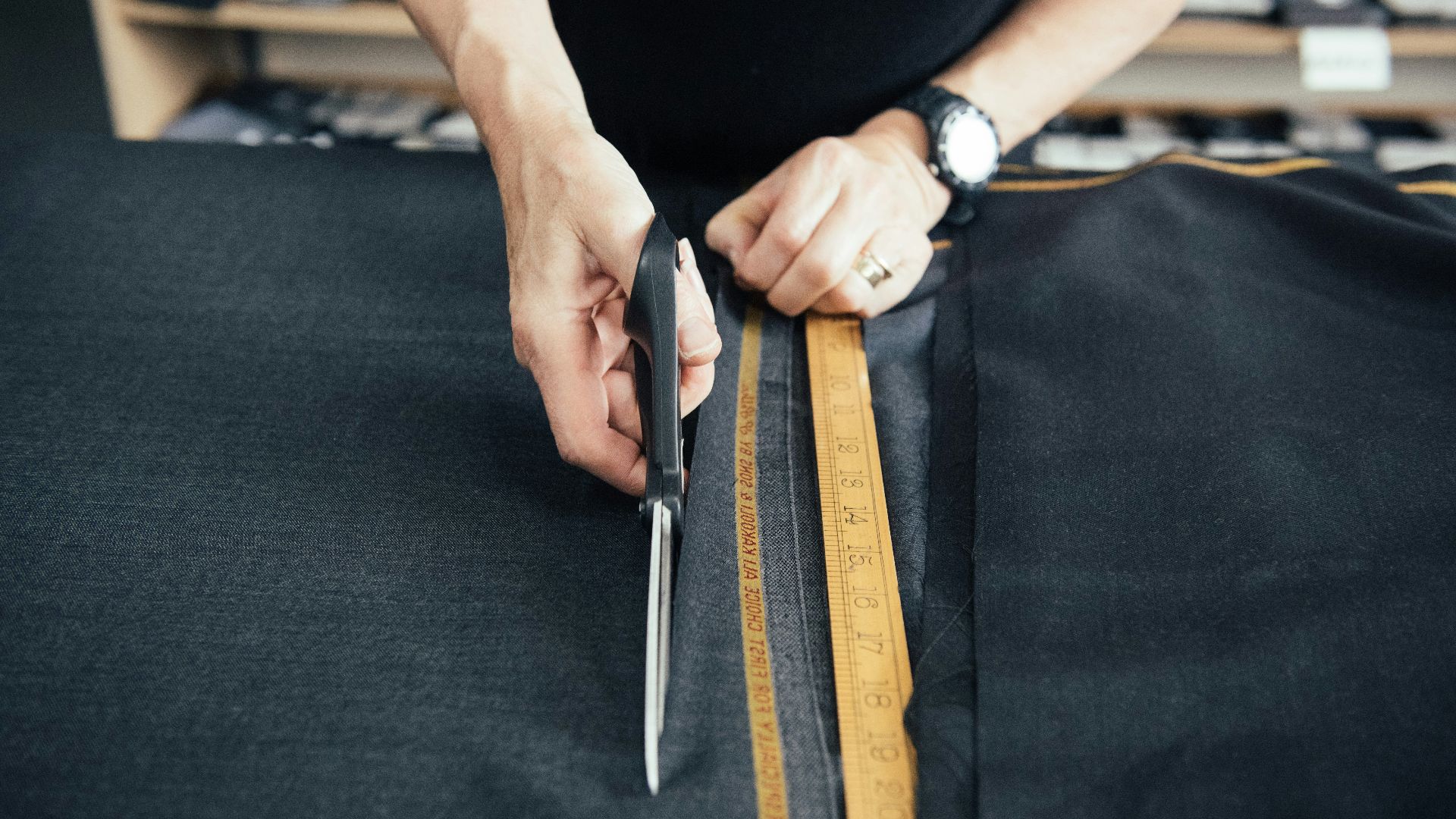 a person cutting a piece of fabric with a pair of scissors