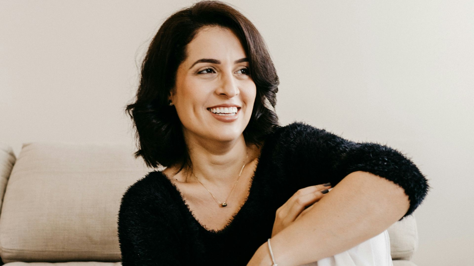 woman in black long sleeve shirt sitting on white couch