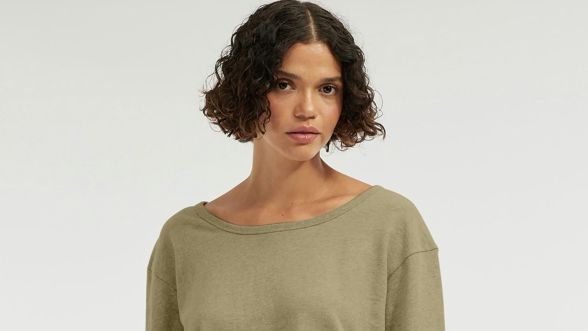 Woman wearing a green long-sleeve shirt and jeans