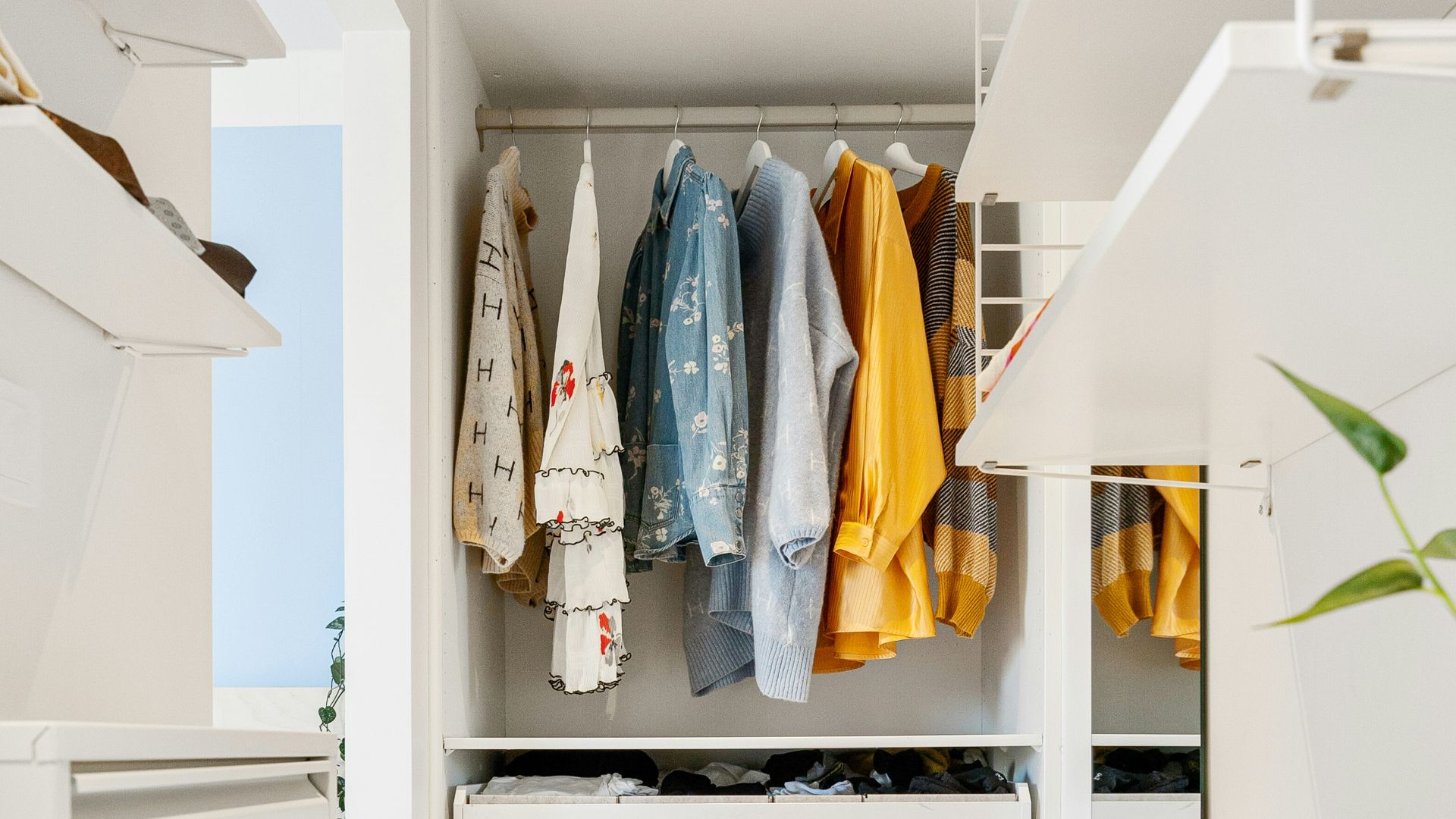 A walk in closet with white cabinets and drawers