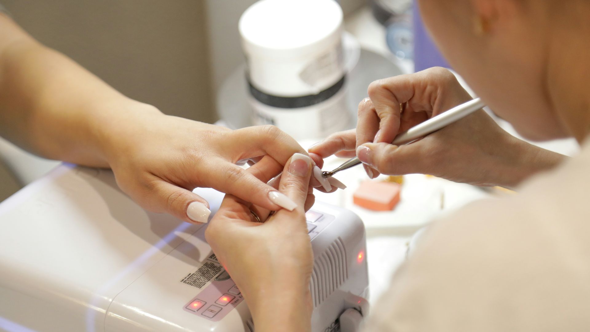a woman getting her nails done at a nail salon
