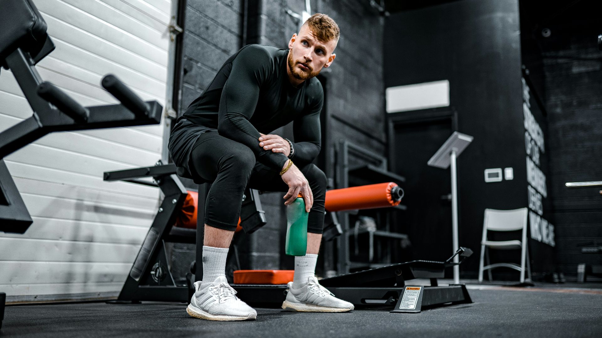 woman in black long sleeve shirt and black pants sitting on exercise equipment
