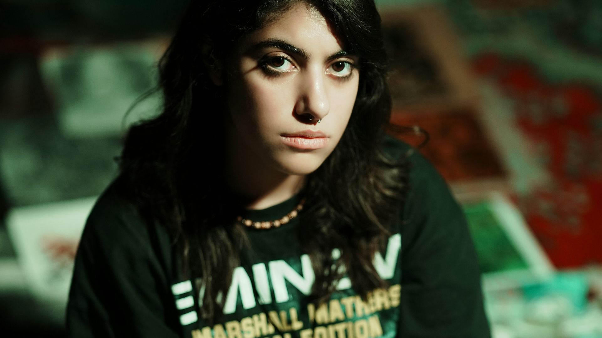 Young woman in eminem t-shirt sits on floor