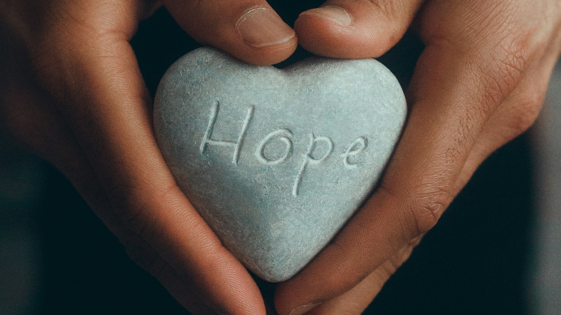 person holding gray heart shape ornament