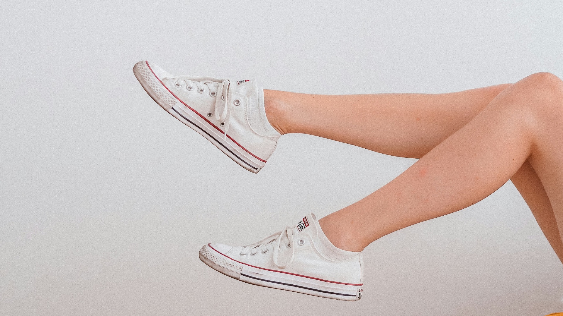 woman in white low top sneakers