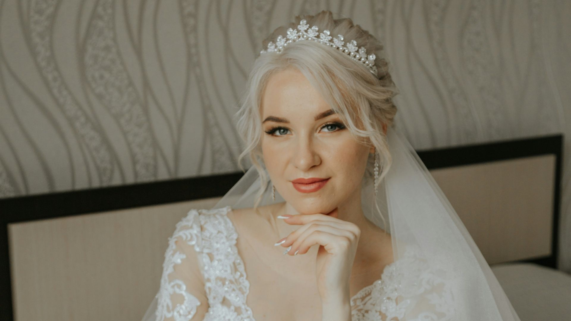 a woman in a wedding dress sitting on a bed