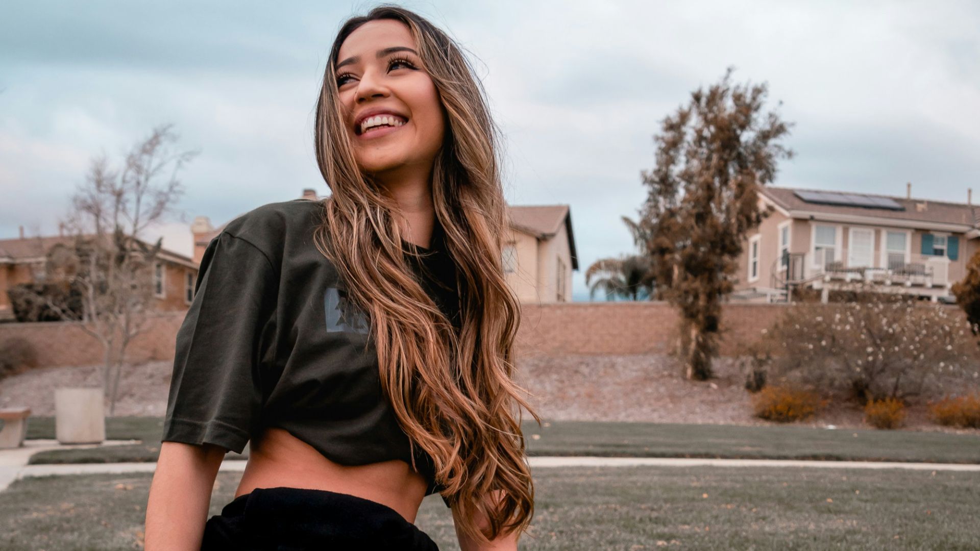 woman in black t-shirt and black pants sitting on ground during daytime