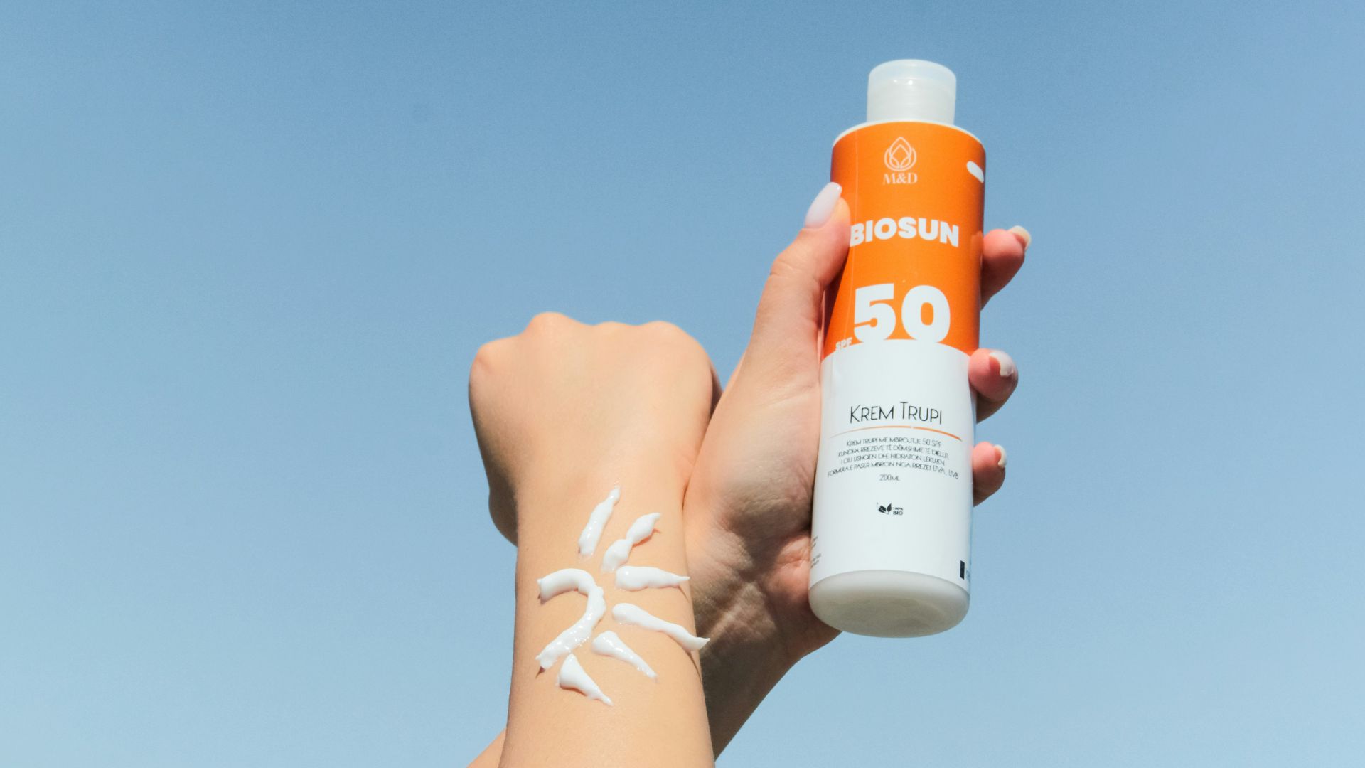 a person holding a bottle of sunscreen in their hand