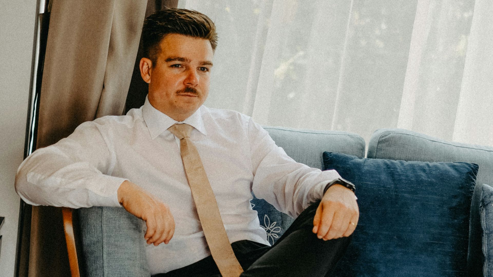 Man in a suit sitting on a couch