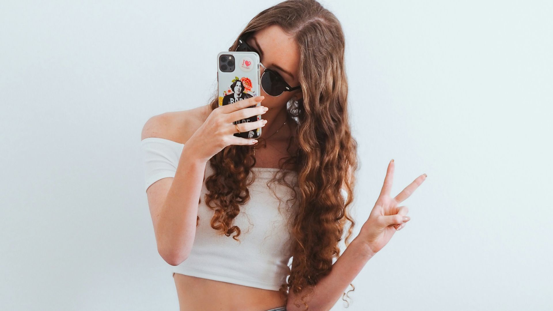 woman in pink tank top and blue denim jeans sitting on yellow chair